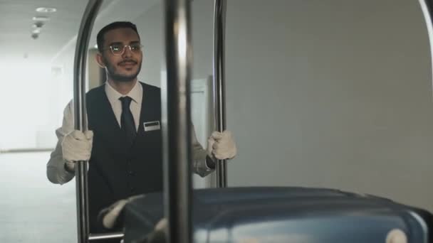 Modern Otelin Boş Koridorlarında Yük Arabası Taşıyan Genç Bir Erkeğin — Stok video