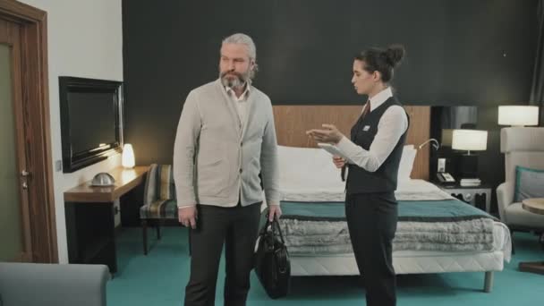 Dijital Tabletle Kadın Otel Müdürünün Modern Rahat Odasında Yetişkin Adamlarına — Stok video