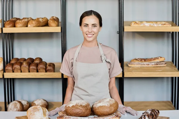 A friss kenyeret árusító pékség boldog fiatal tulajdonosa — Stock Fotó