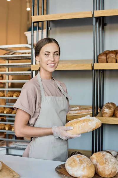 Feliz joven propietaria de panadería vendiendo pan fresco — Foto de Stock