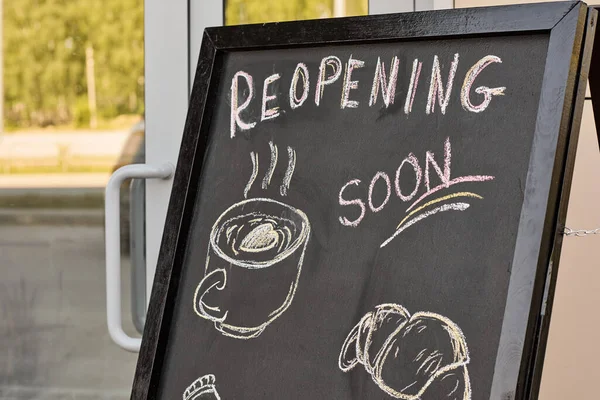 Picture and reopening announcement written with chalk on blackboard — Stock Photo, Image