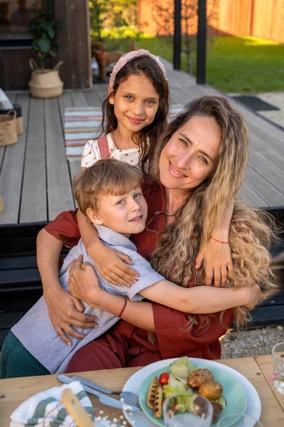 Vrolijke kinderen en hun mooie moeder dineren buiten — Stockfoto