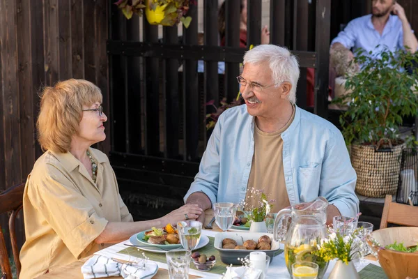 Щасливі літні люди обговорюють своє сімейне життя після обіду у вихідні — стокове фото
