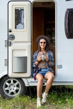 Genç yürüyüşçü yaz tatilinin tadını çıkarırken içki içiyor.