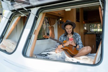 Tekerlekli sandalyedeki akıllı telefondan kayan mutlu genç bayan.