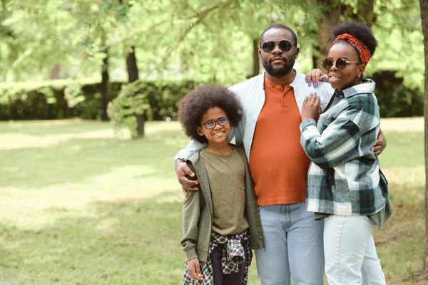 Afectuosa familia africana de tres de pie en el parque —  Fotos de Stock