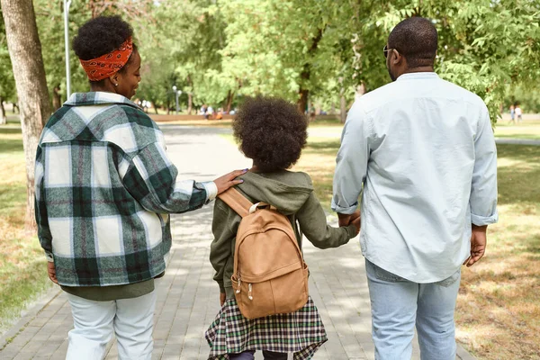 Jonge Afrikaanse vrouw praten met haar zoon met rugzak in park — Stockfoto
