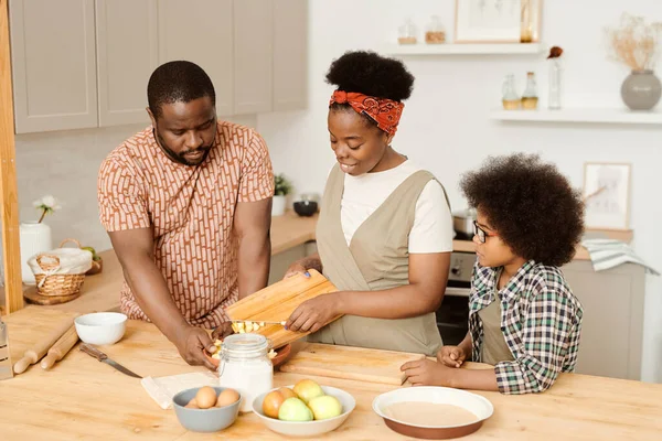 Jong paar en hun zoon koken samen ontbijt — Stockfoto