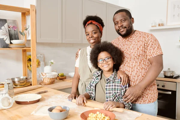 Afrikaanse familie van twee ouders en schattige zoon rollen deeg voor gebak — Stockfoto