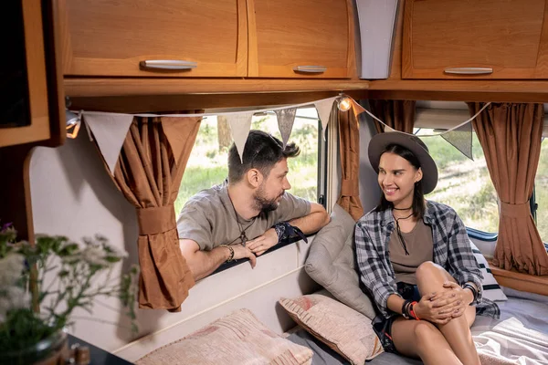 Gülümseyen kız, karavanda yatakta erkek arkadaşıyla etkileşime geçiyor. — Stok fotoğraf