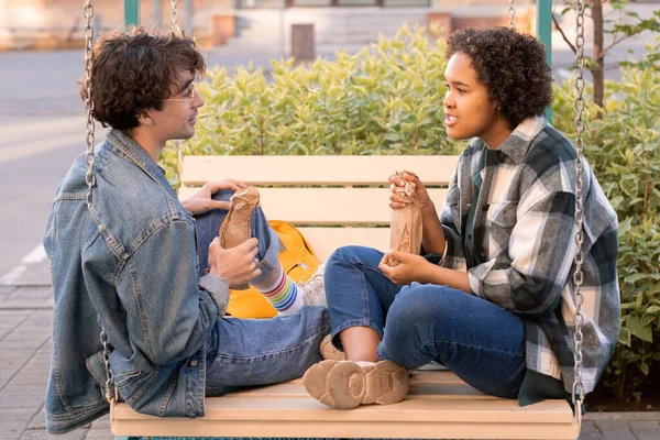 Hedendaagse tiener paar met drankjes bespreken plannen — Stockfoto