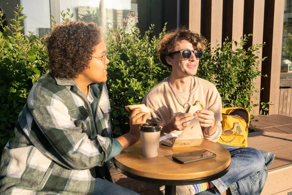 Two happy teenagers having snack and drinking coffee outside — Stock Photo, Image