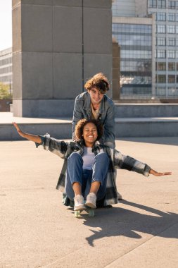 Mutlu adam kız arkadaşını kaykaya iterken ikisi de eğleniyor.