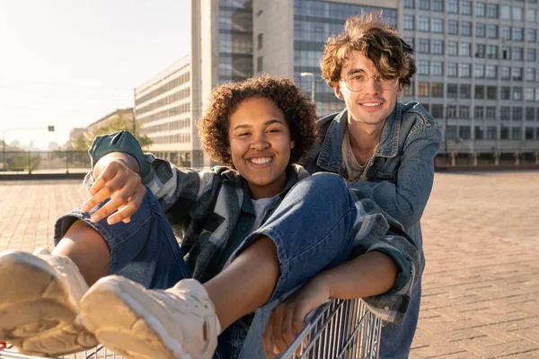Två glada tonåringar som har roligt utomhus mot modern arkitektur — Stockfoto