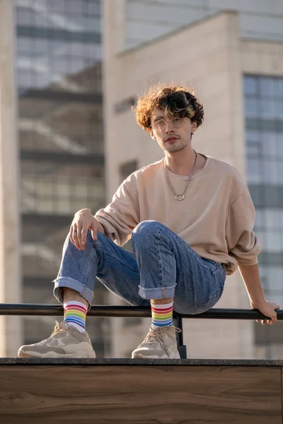Adolescent contemporain en jeans et sweat-shirt assis sur des balustrades — Photo