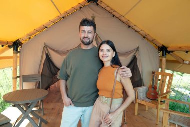 Gülümseyen karı koca, günlük kıyafetleriyle kameraya bakıyor.