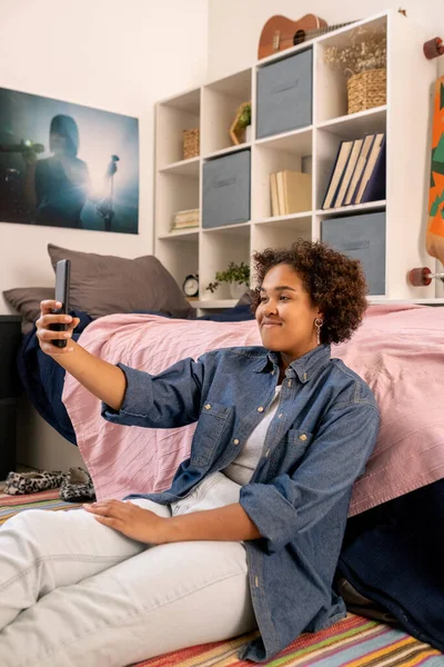 Feliz adolescente africano con teléfono inteligente que se comunica en el chat de vídeo — Foto de Stock