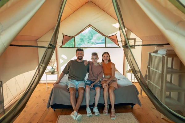 幸せな家族の3つの大きなベッドの上に座っている魅力的な家 — ストック写真