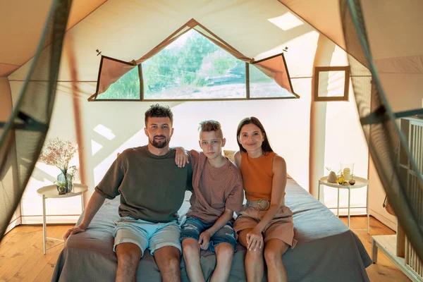 Genç ebeveynler ve genç oğulları glamping evinde dinleniyorlar.