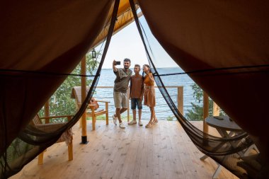 Mutlu aile görüntülü sohbet aracılığıyla iletişim kurarken akıllı telefon ekranına bakıyor