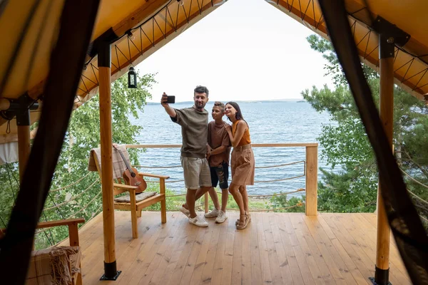 Mutlu bir aile, yaz tatilinde deniz kenarında selfie çekiyor. — Stok fotoğraf