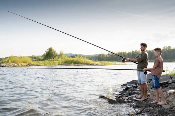 Tonårspojken och hans far fiskar tillsammans på sommarhelgen — Stockfoto