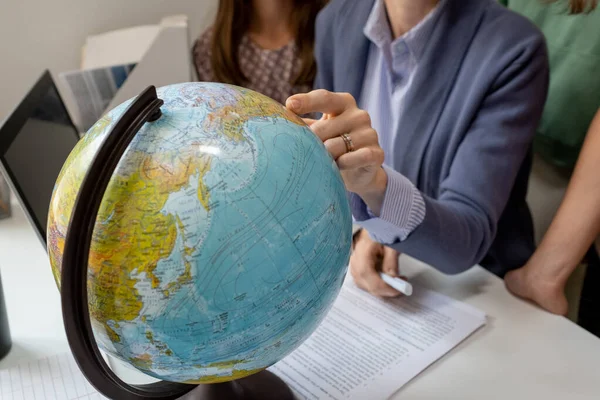 Hand of geography teacher pointing at continent on globe — Stock Photo, Image