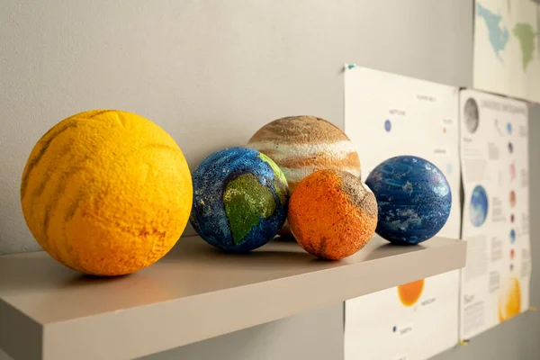 Groep van planeet modellen op plank door witte muur — Stockfoto