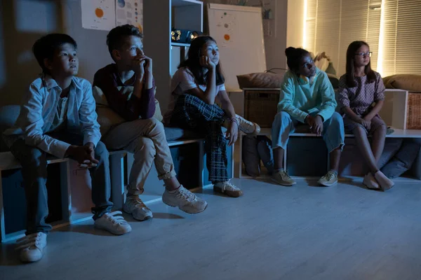 Bir grup çocuk karanlıkta film falan izliyor. — Stok fotoğraf