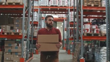 Karton kutular taşıyan ve nalbur deposunda yürüyen erkek işçiyi yavaş yavaş izliyorlar. Arkaplanda stok sayımı yapan Afro-Amerikalı denetçi