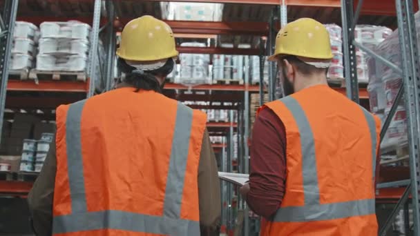 Vista Trasera Seguimiento Lento Los Trabajadores Masculinos Chalecos Naranjas Sombreros — Vídeo de stock