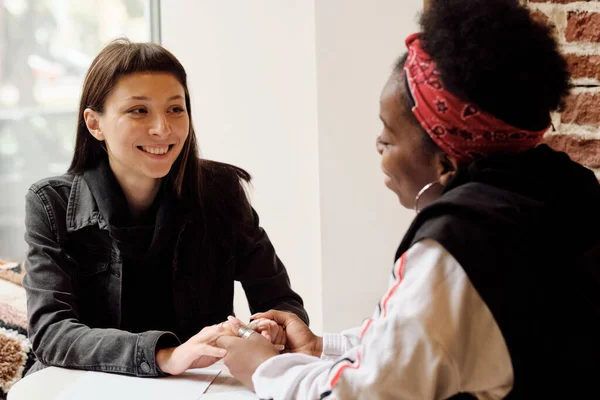 행복 한 젊은 백인 여성 이 아프리카 여자 친구와 이야기하는 모습 — 스톡 사진