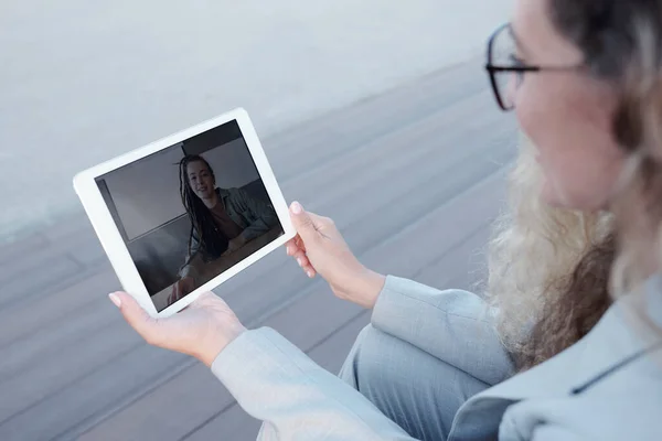 Jeune femme d'affaires élégante avec tablette communiquant en vidéo-chat — Photo