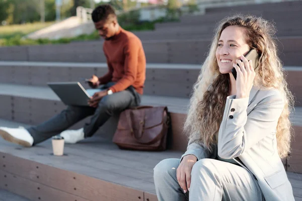 Blond affärskvinna med smartphone genom örat kommunicera utomhus — Stockfoto