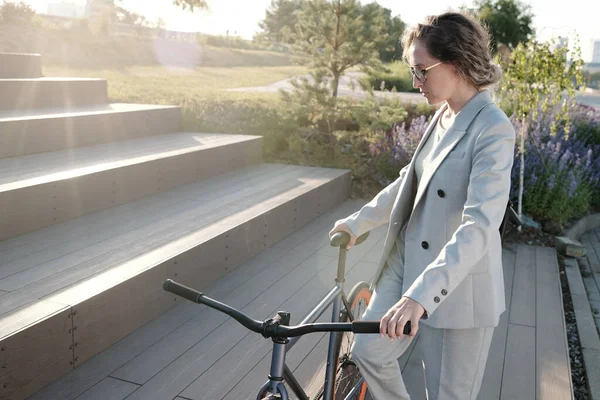 Zakenvrouw met fiets naar boven in stedelijke omgeving — Stockfoto