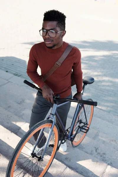 Gözlüklü genç işadamı ve bisiklet iten şık giyimli. — Stok fotoğraf