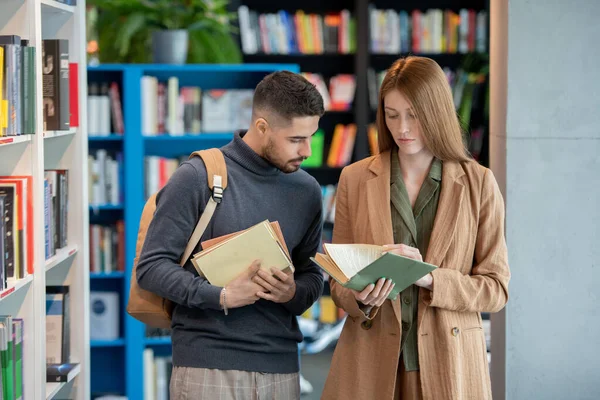 Dwóch młodych studentów wybierających książki w bibliotece lub księgarni — Zdjęcie stockowe