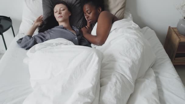 Powolne Śledzenie Ujęcia Szczęśliwej Wieloetnicznej Pary Lesbijek Śpiącej Przytulnym Łóżku — Wideo stockowe