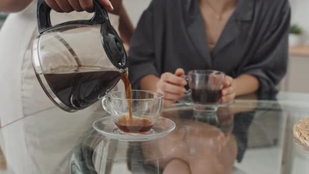 午前中にコーヒーをグラスカップに注ぐアフリカ系アメリカ人女性の認識できない部分のスローモ — ストック動画