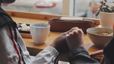 Orta kesimde tanınmayan eşcinsel kadınların el ele tutuştuğu bir yer. Pencere kenarında oturmuş el ele tutuşuyorlar.