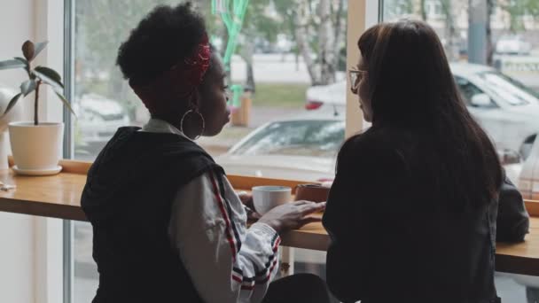 Kafenin Penceresinde Oturup Sohbet Eden Neşeli Afro Amerikan Kadın Kafkasyalı — Stok video