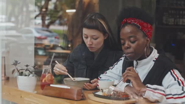 Медленно Выстрелил Окно Кафе Молодых Кавказских Афроамериканских Женщин Наслаждающихся Едой — стоковое видео