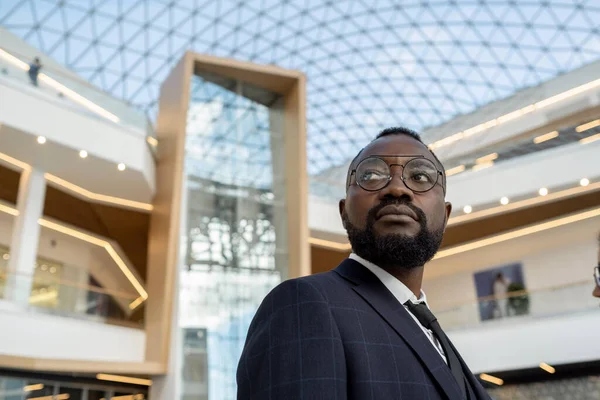 Fiatal, komoly afrikai üzletember a modern építészet ellen — Stock Fotó