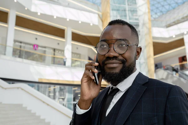 Glad ung afrikansk affärsman som håller smartphone i örat — Stockfoto