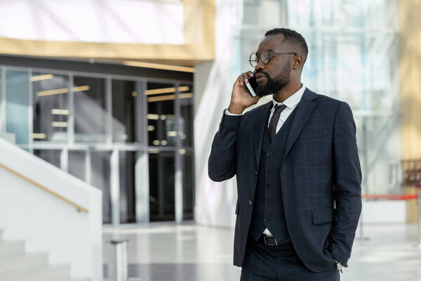 Young elegant businessman communicating on mobile phone