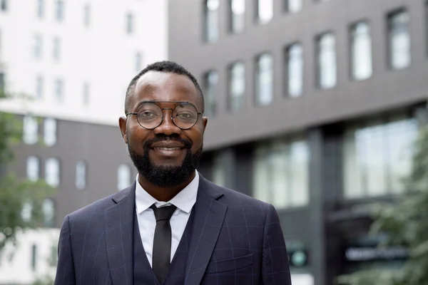 Feliz joven empresario africano de pie en el entorno urbano — Foto de Stock