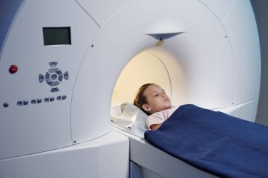 MRI işleminden önce uzun masada yatan tatlı küçük kız.