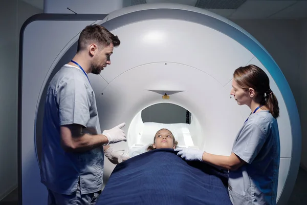 Один з двох радіологів консультує маленького пацієнта перед оглядом — стокове фото