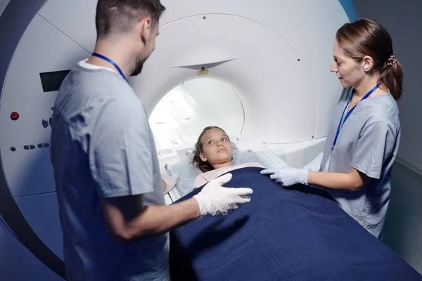 Söt liten patient tittar på en av röntgenfotografer innan MRI scan undersökning — Stockfoto