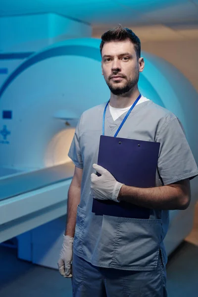 Jovem médico contemporâneo em uniforme segurando documento médico — Fotografia de Stock